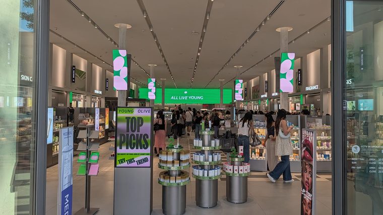 View through the entrance of Olive Young’s first US store in Pasadena, with shoppers browsing skincare displays